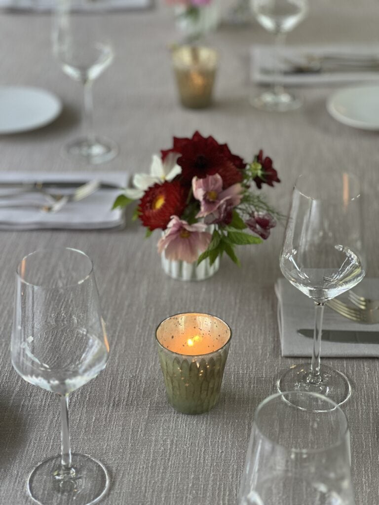 Elegant dining table with candle and flower arrangement.